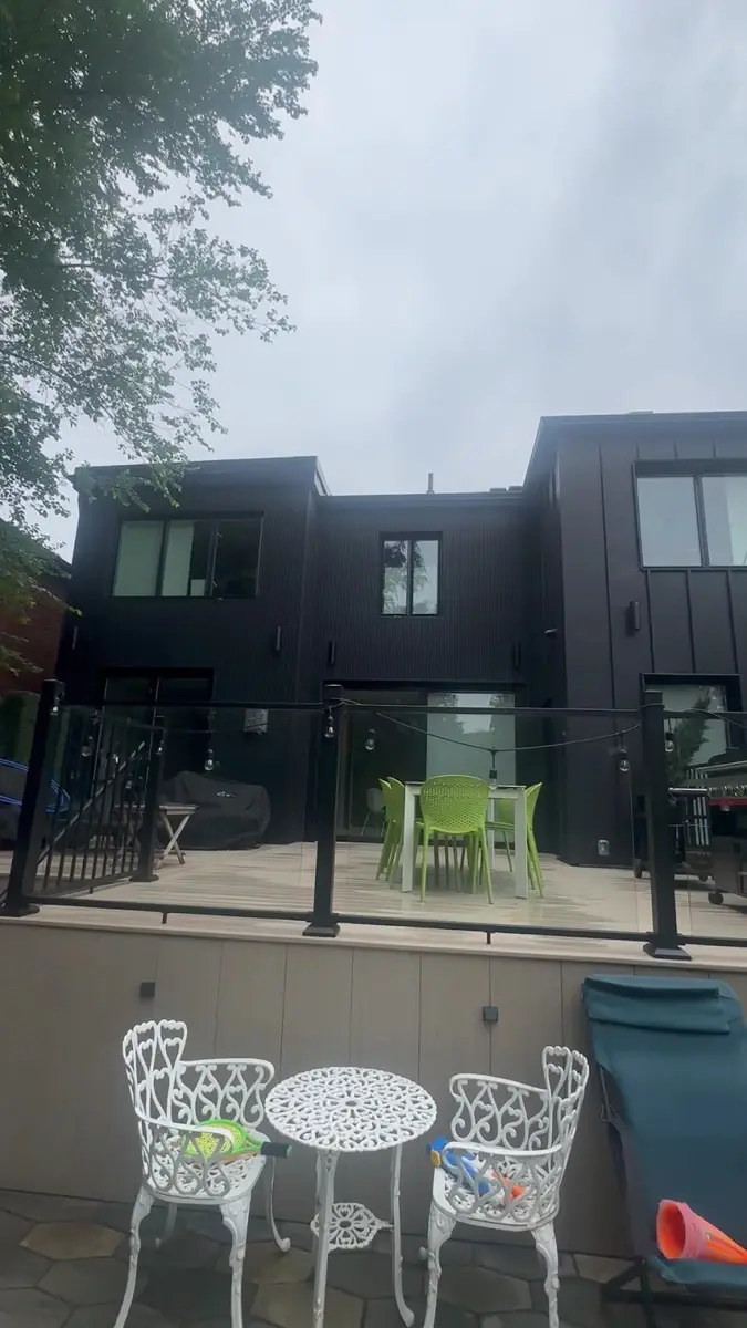 Modern dark-sided home and backyard deck after cleaning